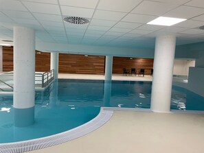 An indoor swimming pool with clear water, surrounded by white pillars and wooden walls. - Studio 6 pers, pool, pets allowed - Gourette (Gourette)