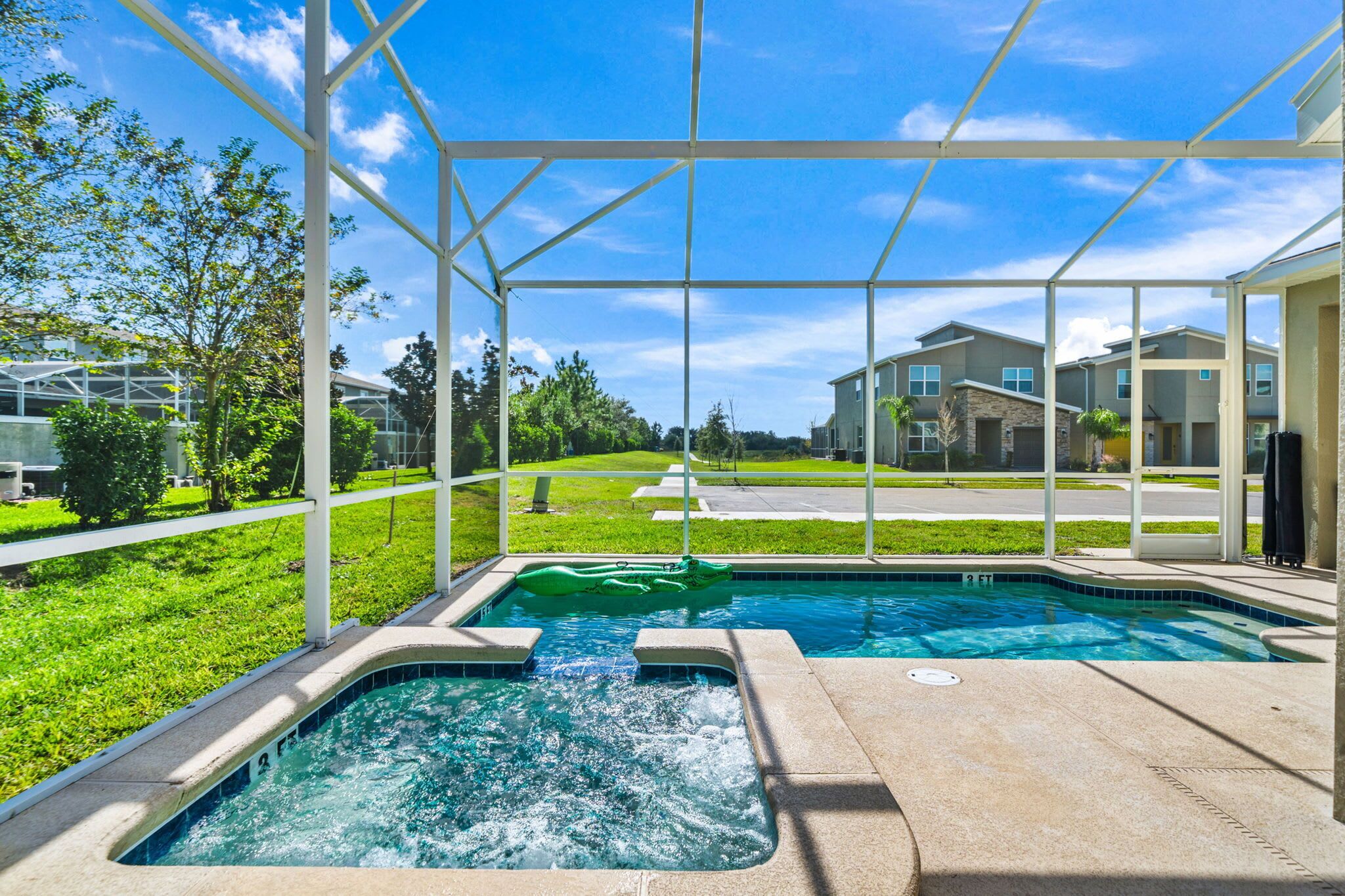 Una piscina con idromassaggio, circondata da un'area coperta con vista sugli edifici residenziali.