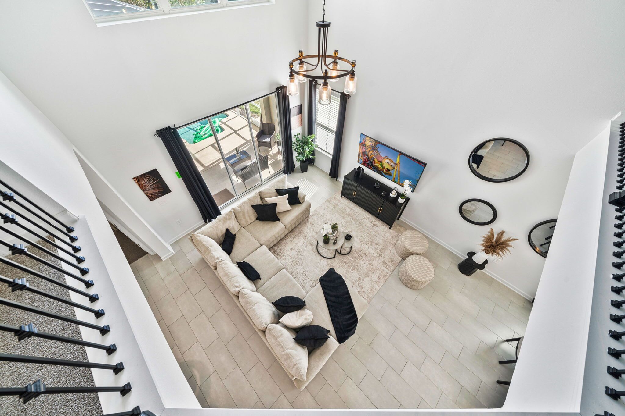 A spacious living area with a sectional sofa, a coffee table, and a chandelier.