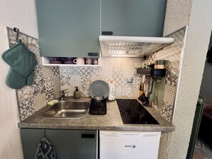 A compact kitchen with a dishwasher, a sink, a stove, and a small countertop. - Renovated cozy studio with south balcony - 2 pers. (Arâches-la-Frasse)