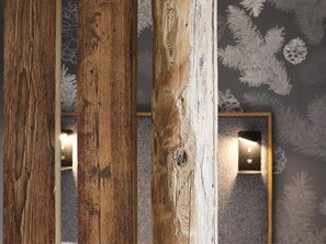 A close-up of wooden beams with a textured wall featuring a leaf pattern in the background. - Renovated and cozy studio with Wifi and pets allowed near center (Arâches-la-Frasse)