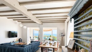 A spacious living area with a sectional sofa, a dining table with chairs, and a view of the outdoors. - Holiday Home “Les Sables Pailletés 14p” with Sea View, Shared Terrace & Wi-Fi (Les Sables-d'Olonne)