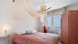 Un dormitorio con cama, mesita de noche, armario y ventana con vistas.