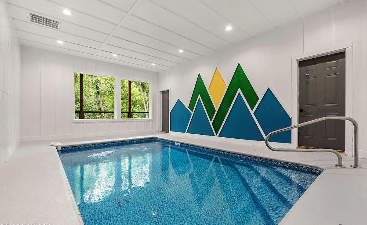 An indoor swimming pool with a clear view of the surrounding walls and windows.