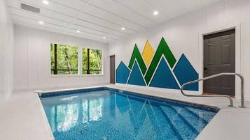 An indoor swimming pool with a clear view of the surrounding walls and windows.