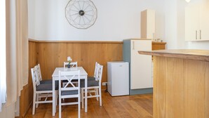 A compact kitchen with a white refrigerator, a wooden countertop, and a wall-mounted clock. - Apartment '2' with Wi-Fi (Bad Kissingen)