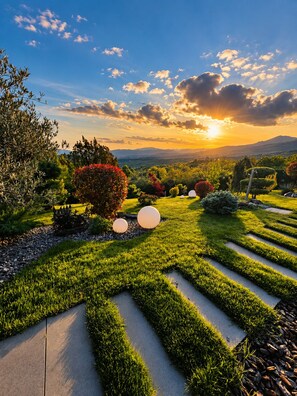A landscaped garden with pathways, trees, and spherical sculptures.