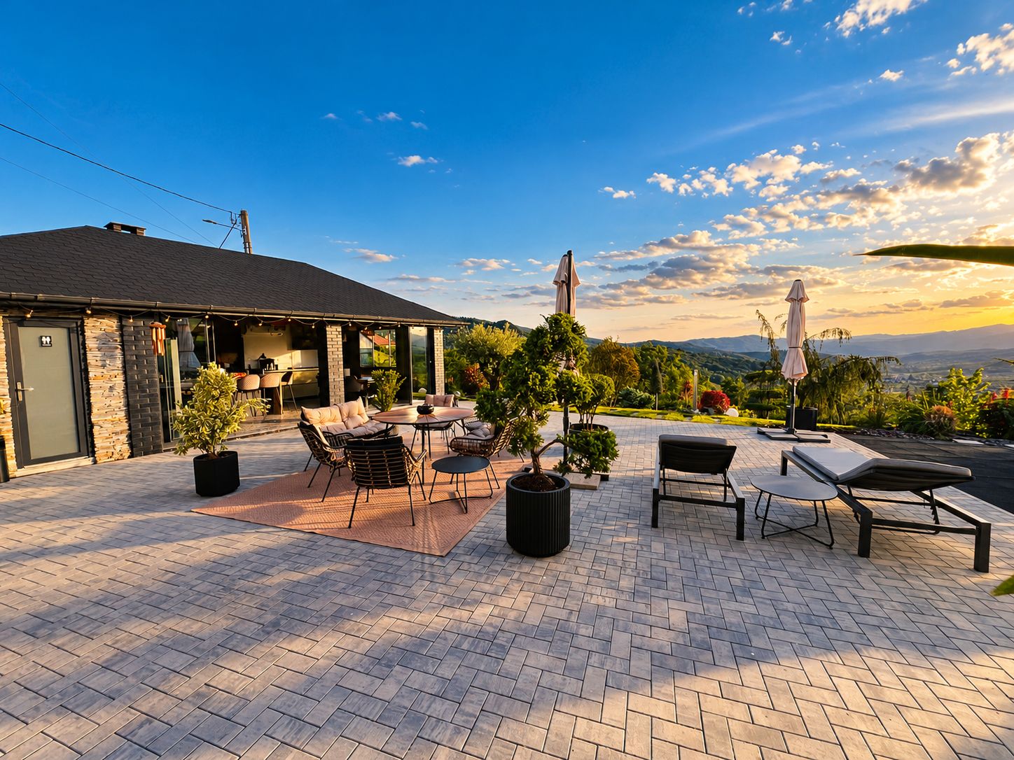 An outdoor patio with seating, a barbecue area, and a view of the landscape.