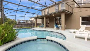 A swimming pool with a glass ceiling, surrounded by lounge chairs and a patio area. - Upstay Home w Pool Hot Tub Patio - Pet Friendly (Kissimmee)