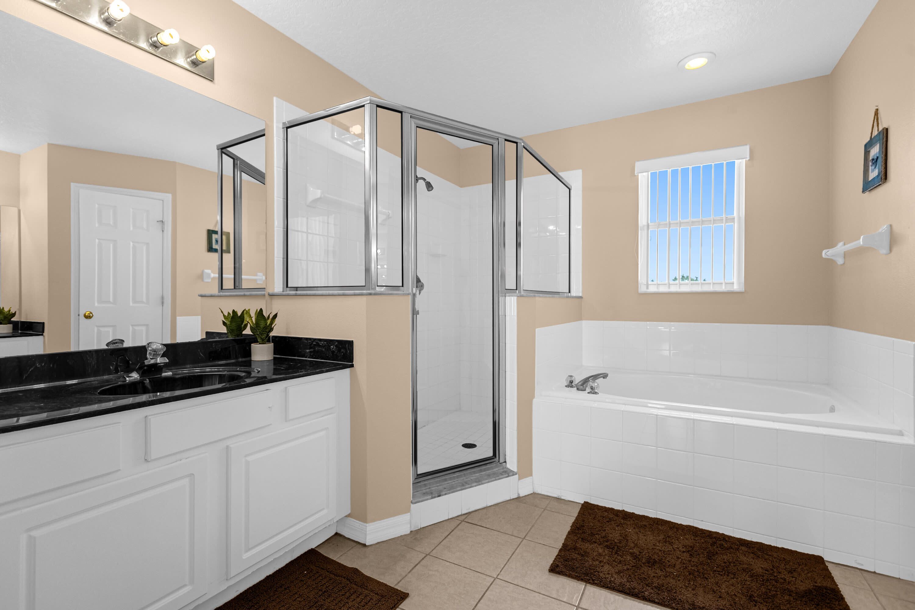 A modern bathroom with a walk-in shower, a large bathtub, and a vanity with a sink.