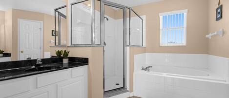 A modern bathroom with a walk-in shower, a large bathtub, and a vanity with a sink.