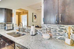 A modern kitchen with granite countertops, stainless steel appliances, and a tiled backsplash.