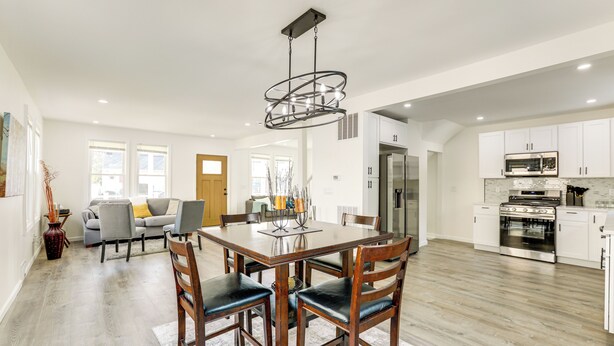 A spacious kitchen with modern appliances, a dining area with a wooden table and chairs, and a living room with a sofa and decorative vase. - Private Yard! East Jersey Hub By River & Soccer! (National Park)