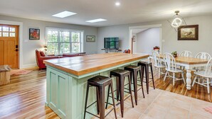 A spacious kitchen with a large island, bar stools, and a dining table with chairs. - Serene Getaway w/ Trail Access in Chester Springs (Chester Springs)