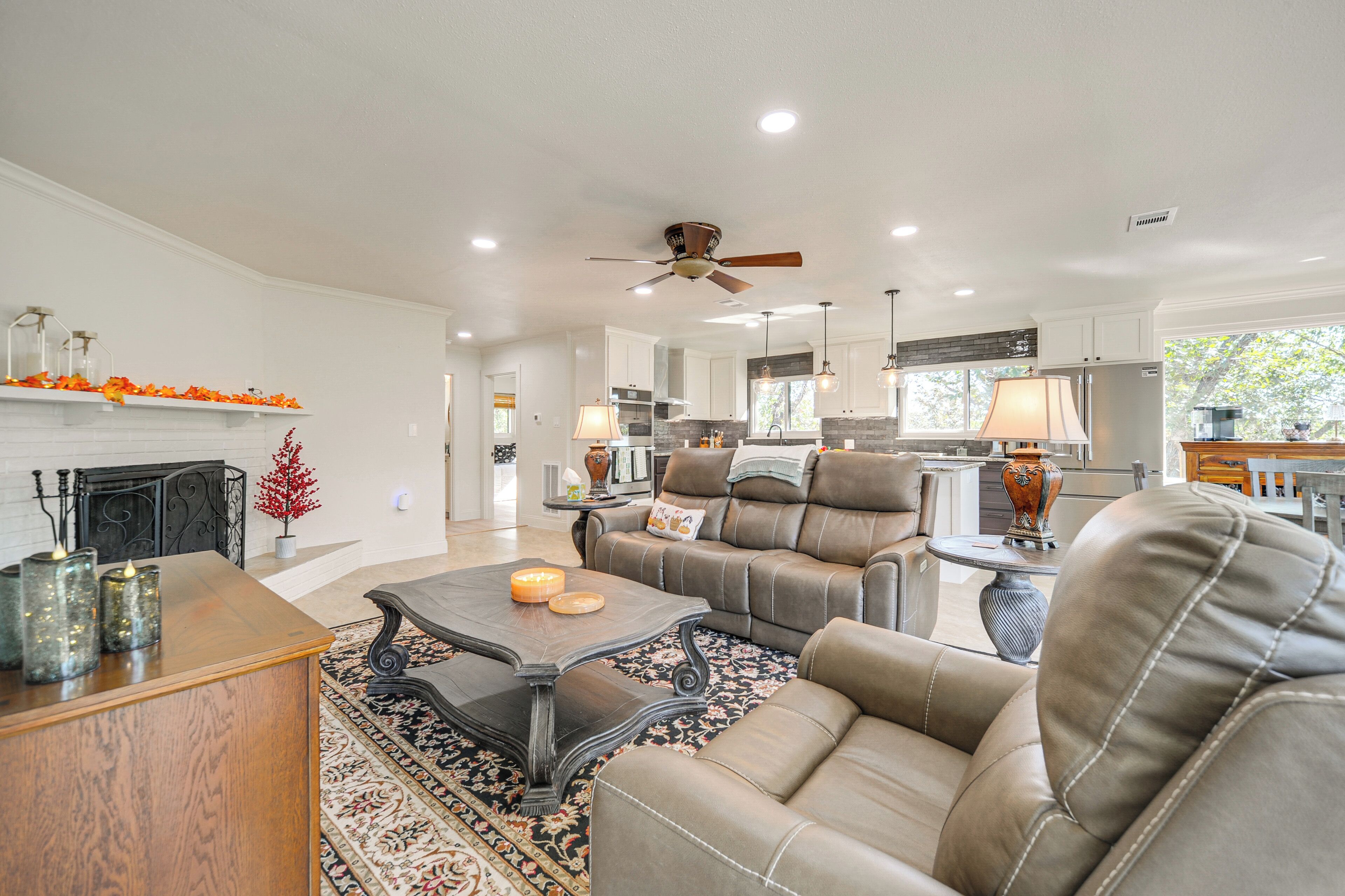 A spacious living room with a fireplace, leather sofas, and a coffee table.