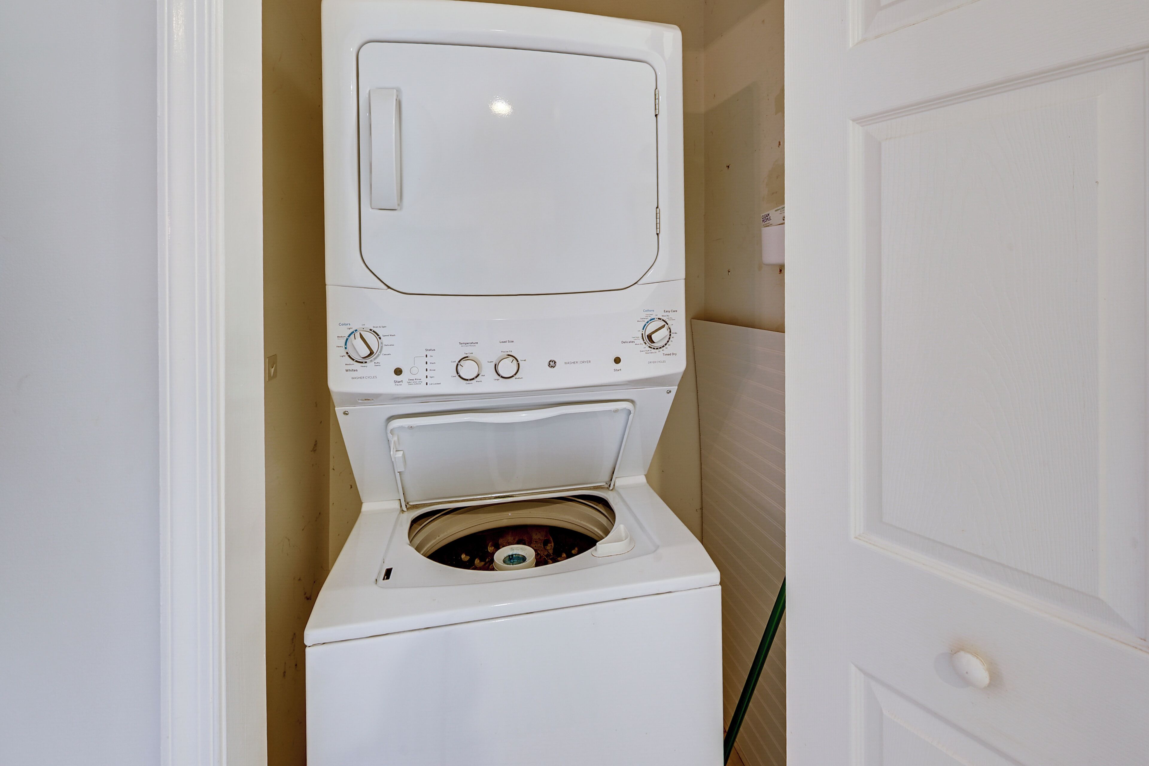A compact, white front-loading washer and dryer unit with a control panel featuring multiple dials and buttons.