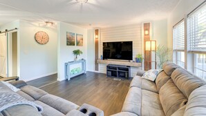 Ein modernes Wohnzimmer mit einem großen Flachbildfernseher, einem bequemen Sofa und einer Holz-Unterhaltungseinrichtung.