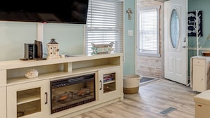 Ein Wohnzimmer mit Kamin, Fernseher und Dekoration.