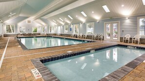 Ein Hallenbad mit deutlichen Fahrbahnen, einem gefliesten Boden und einer Decke mit Dachfenstern.