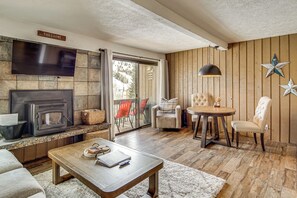A cozy living room with a fireplace, a television, and a dining area with a table and chairs. - 1 Mi to Brian Head Resort! Mtn-view Gem w/ Shuttle (Brian Head)