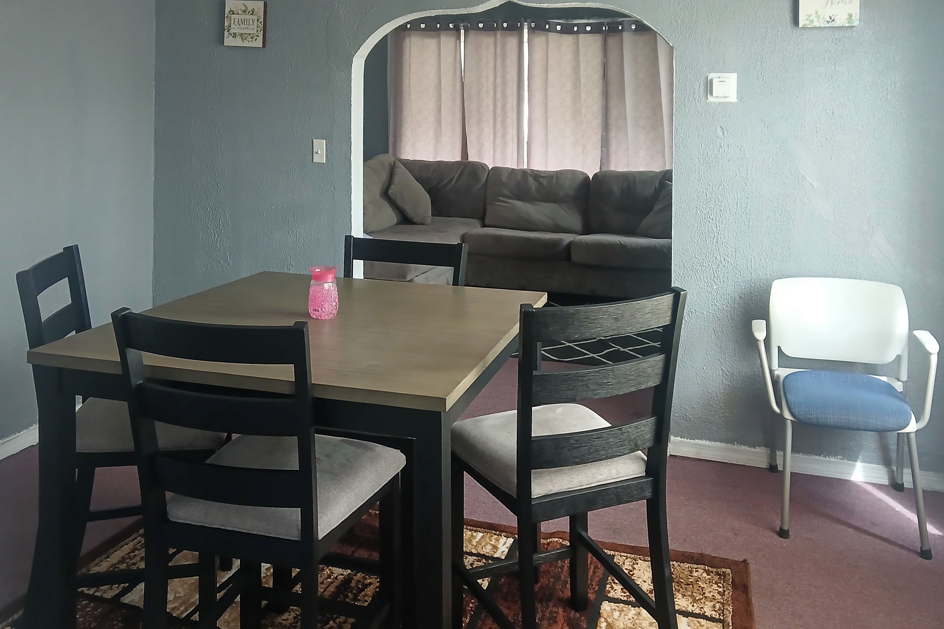 A dining area with a table, chairs, and a sofa.