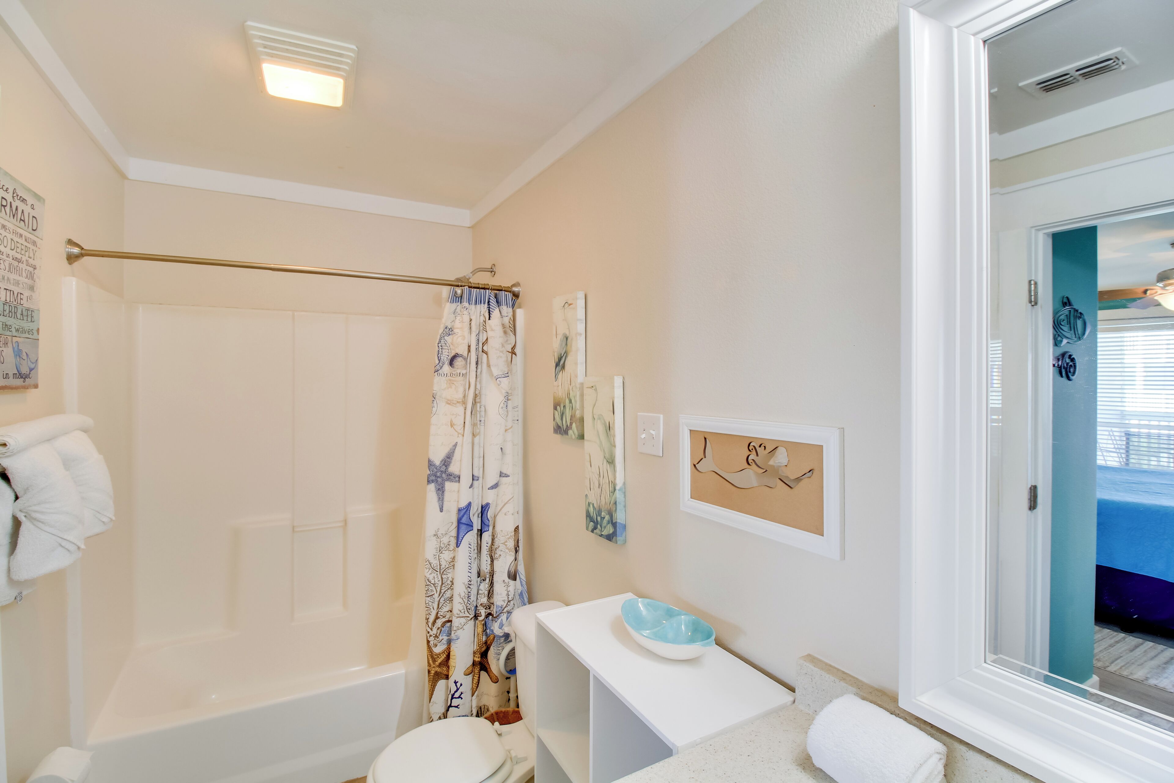 Une salle de bain équipée d’une baignoire, de toilettes, d’un rideau de douche et d’un lavabo avec un receveur.