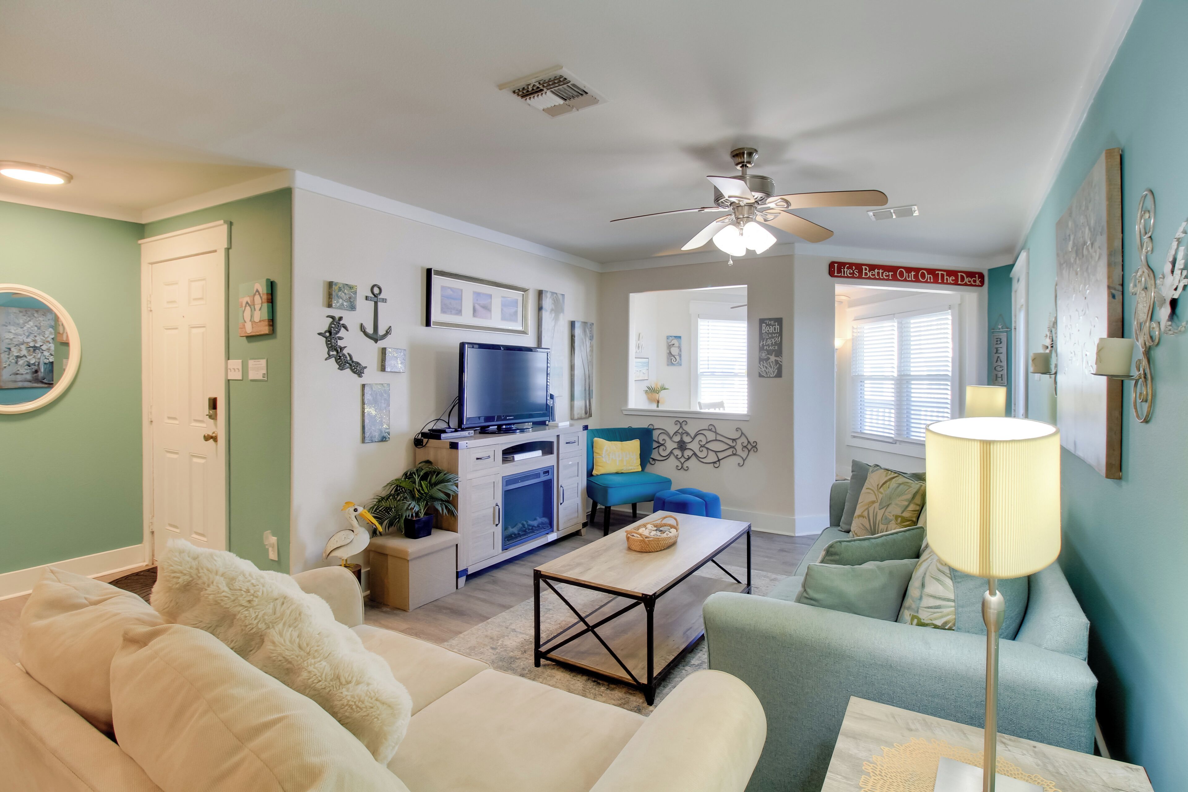 A living room with a ceiling fan, a television, a coffee table, and a sofa.