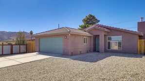 A single-story house with a garage, a small attached structure, and a gravel driveway. - Family Home, 7 Mi to Joshua Tree National Park! (Twentynine Palms)
