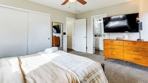 A bedroom with a bed, a dresser, a television, and a ceiling fan. - Fenced-in Yard w/ Deck: Pet-friendly Lochbuie Home (Brighton)