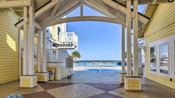 A covered outdoor area with a view of the beach, featuring a pool area and a sign indicating the pool is closed. - Steps to Private Beach: Galveston Resort Condo! (Galveston)