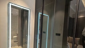 A modern bathroom with a glass shower enclosure, a visible toilet, and a tiled floor. - ACE STAYZ Sector57 Gurugram (Gurugram)