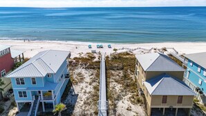 A beachfront property with multiple buildings, a sandy beach, and a clear view of the ocean. - High-end 4BR Condo w/ Gulf & Lagoon views, heated pool & hot tub (Gulf Shores)