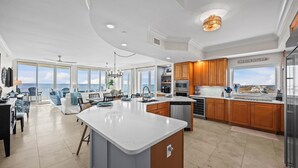 A spacious kitchen with a large island, wooden cabinets, and a view of the beach. - High-end 4BR Condo w/ Gulf & Lagoon views, heated pool & hot tub (Gulf Shores)