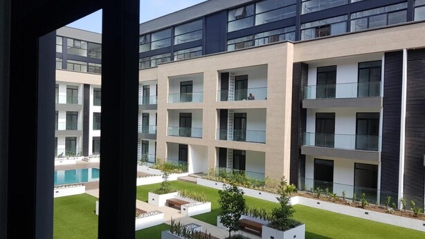 A modern building with multiple balconies and a pool area. - Cozy Nuggets at Embassy Gardens (Accra)