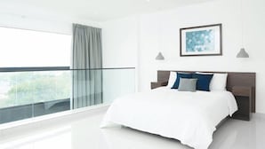 A modern bedroom with a large window, a balcony, and a framed abstract artwork on the wall. - Cozy Nuggets at Embassy Gardens (Accra)