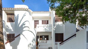 Un edificio blanco con escaleras, una puerta y un ventanal.