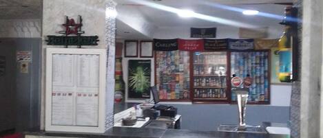 A reception area with a marble counter, a menu board, and a decorative ceiling.