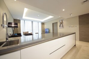 A modern kitchen with a large island, built-in appliances, and a sleek design. - Luxury 1BR at Sterling East Burj Views (Dubai)
