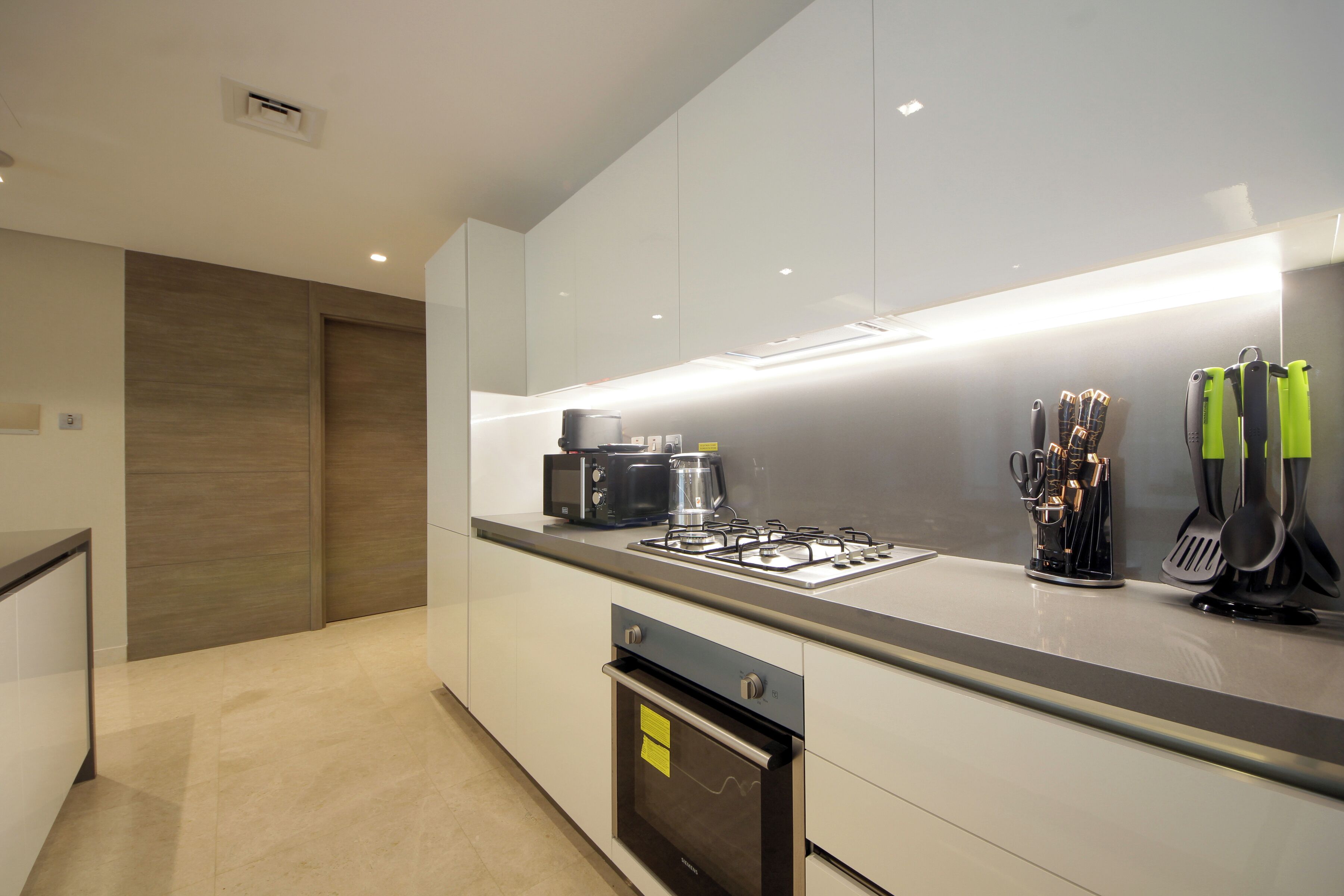 A modern kitchen with a gas stove, built-in oven, and stainless steel appliances.