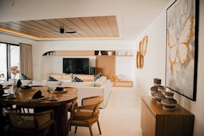 A modern living room with a sofa, dining area, and a TV. - Sale45% Villa 4BR @Seminyak near Double Six Beach (Seminyak)