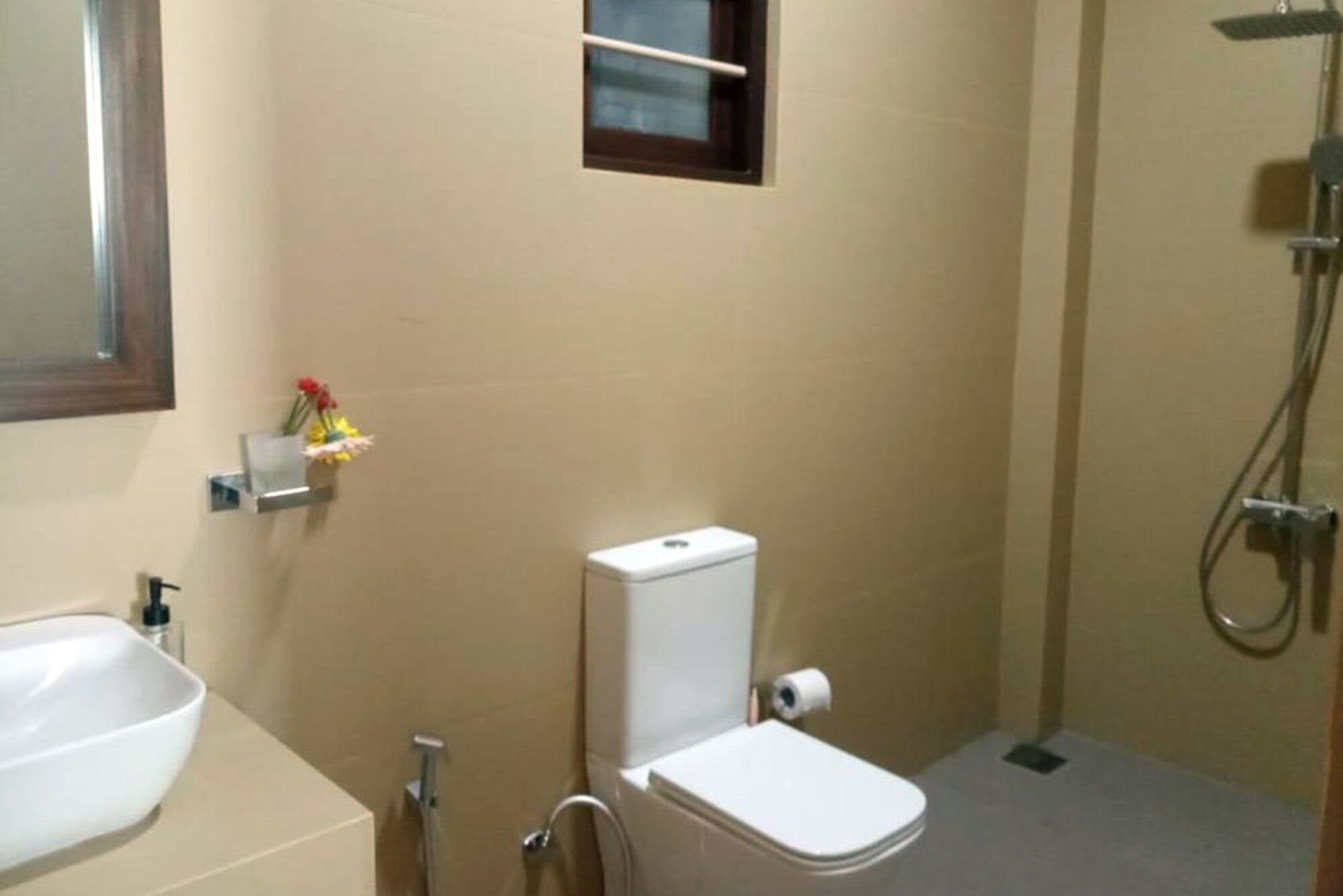 Un baño pequeño con inodoro, lavamanos y ducha.