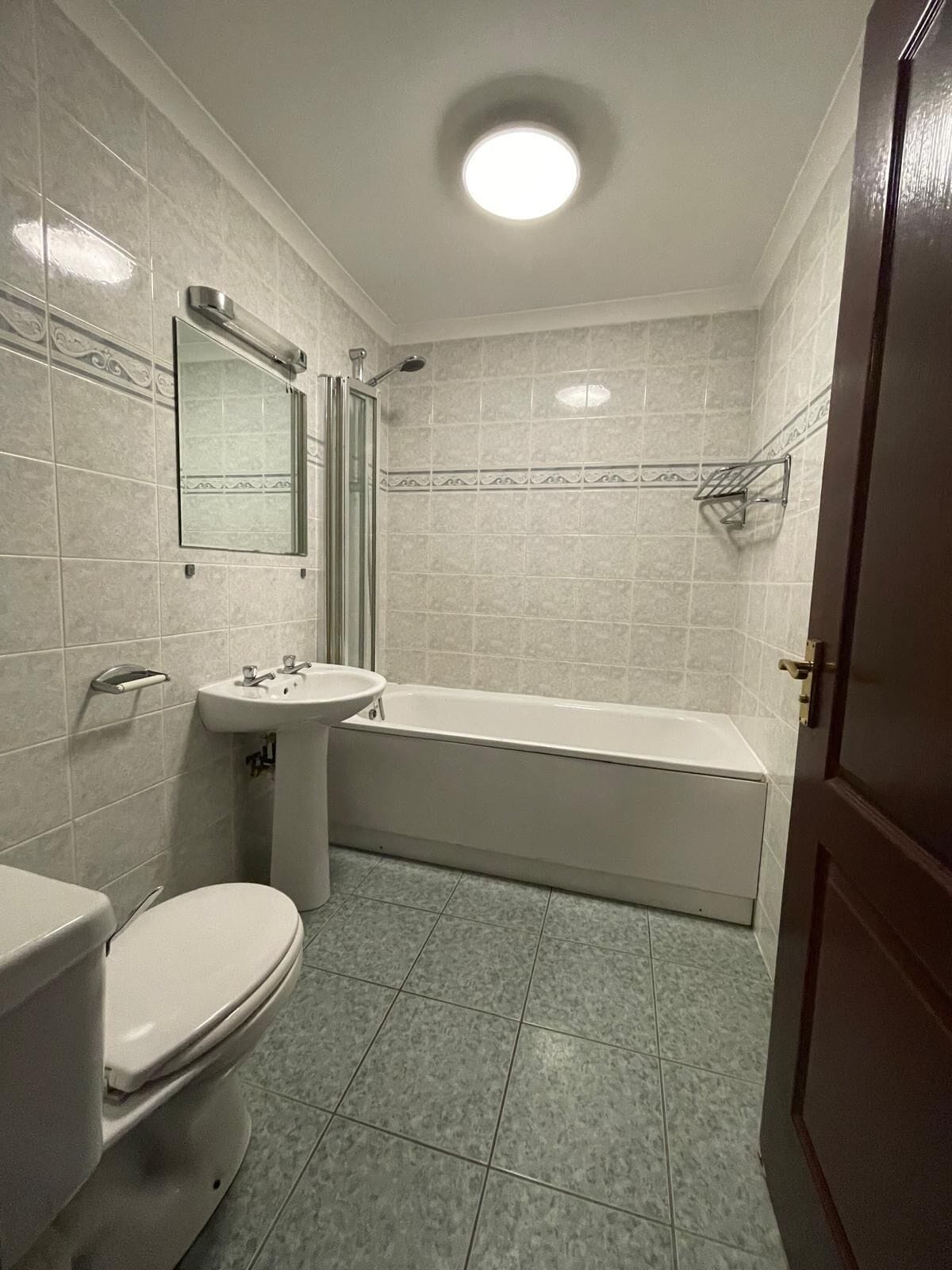 Een badkamer met toilet, wastafel en bad.