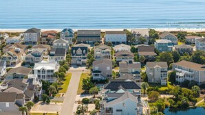 Un área residencial costera con casas, una playa y una vista despejada del océano.
