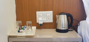 A minibar with a kettle, glasses, and toiletries. - KRISHNA SAI SUITES (Rahata)