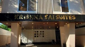 A building with a sign reading "KRISHNA SAISUITES" at the entrance. - KRISHNA SAI SUITES (Rahata)