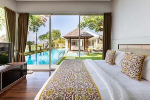 Un dormitorio con una cama grande, televisión y vistas a una piscina y zona exterior.