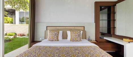 Una habitación de hotel moderna con una cama grande, un escritorio integrado y un amplio ventanal con vistas al jardín.