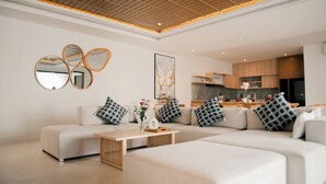 A modern living room with a sectional sofa, a coffee table, and decorative mirrors on the wall. - SALE40% Seminyak Villa 3BR around ShiShi Nightclub (Seminyak)