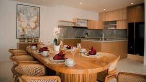 A modern dining area with a wooden table set for six, surrounded by wicker chairs. - SALE40% Seminyak Villa 3BR around ShiShi Nightclub (Seminyak)