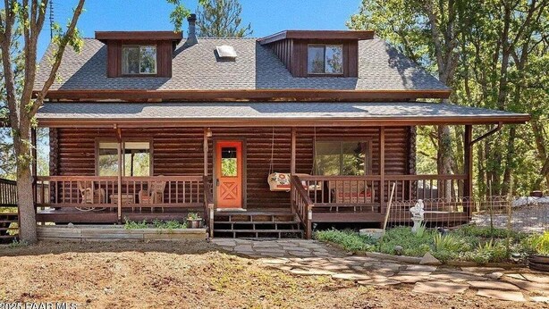 A wooden cabin with a porch, two windows, and a red door. - Minnie Mine Cabin Retreat 4 Bedroom Cabin (Prescott)